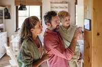 Familie nutzt Smart Home Tablet im Haus