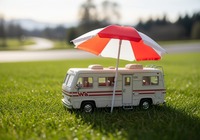 Spielzeug-Wohnmobil wird von einem Sonnenschirm geschützt