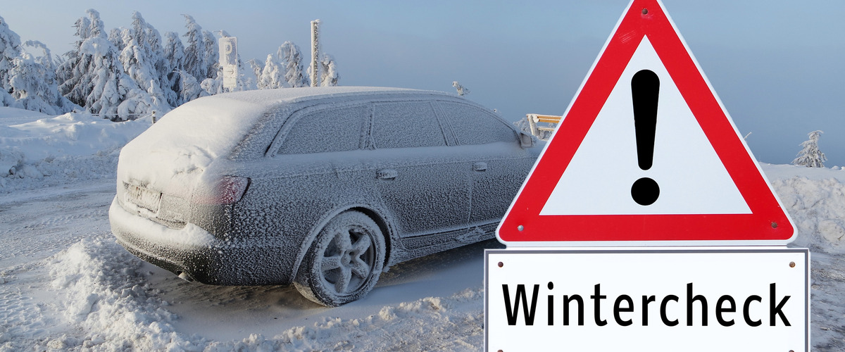 Eingeschneites Auto steht hinter einem Hinweisschild "Wintercheck"