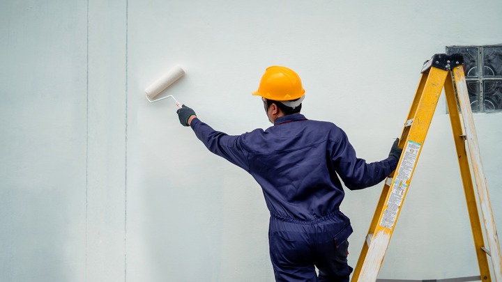 Maler streicht eine Hauswand